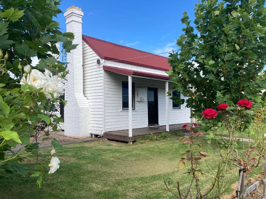 a small white house with a red roof at The Cottage in Bairnsdale