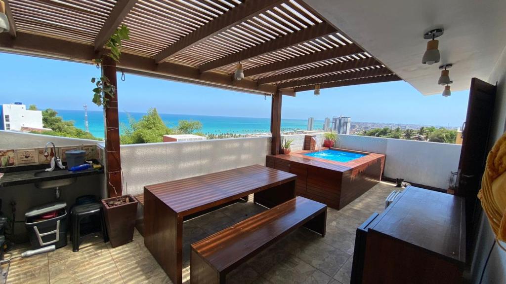 een balkon met een tafel en een zwembad bij Cobertura R2 Maceió in Maceió