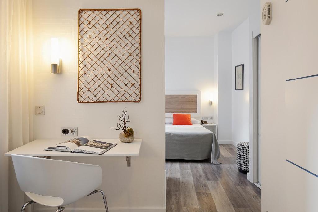 a bedroom with a bed and a desk with a chair at Hotel Santa Rosa, Blue Hoteles in Gijón