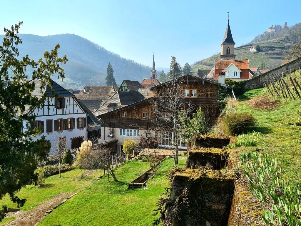 a village with houses and a church on a hill at La Grange du couvent B&B in Ribeauvillé