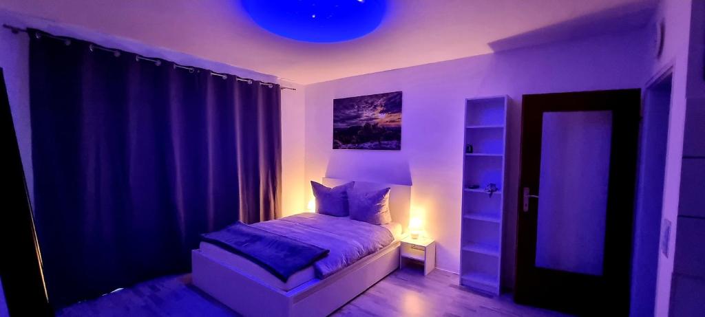 斯圖加特的住宿－MsApartment Stylish wohnen in STUTTGART，一间卧室配有一张蓝色的灯光床