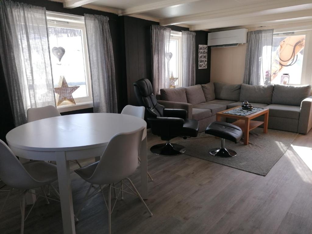 ein Wohnzimmer mit einem Sofa, einem Tisch und Stühlen in der Unterkunft Sommerstue Hessdalen in Ålen