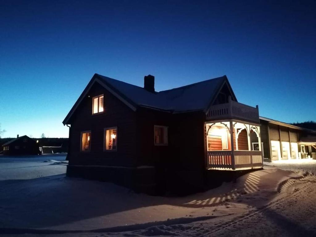 una casa con sus luces encendidas por la noche en Sommerstue Hessdalen en Ålen