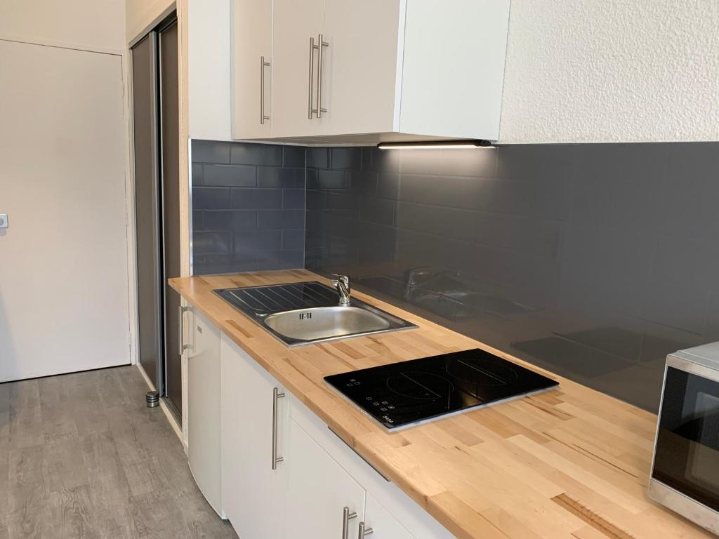 a kitchen with a sink and a counter top at Studio entièrement rénové avec parking gratuit in Saint-Nazaire