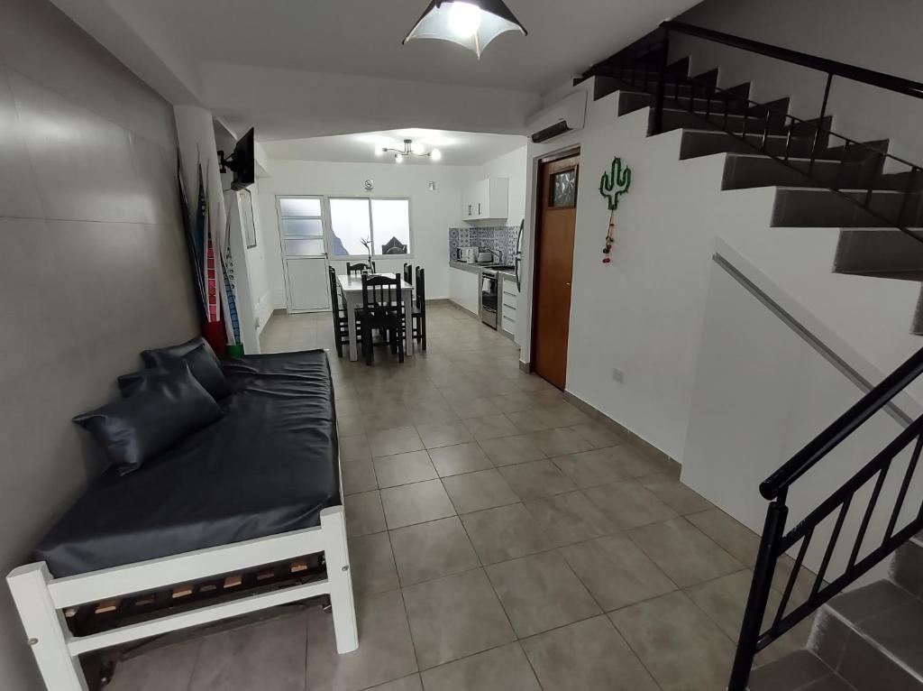 sala de estar con cama y escalera en Los Nardos Duplex en San Salvador de Jujuy