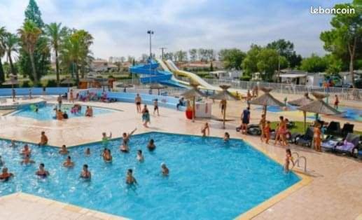 um grupo de pessoas em uma piscina em um parque aquático em MOBIL-HOME NEUF 2021 3CH 34 M2 em Saint-Cyprien