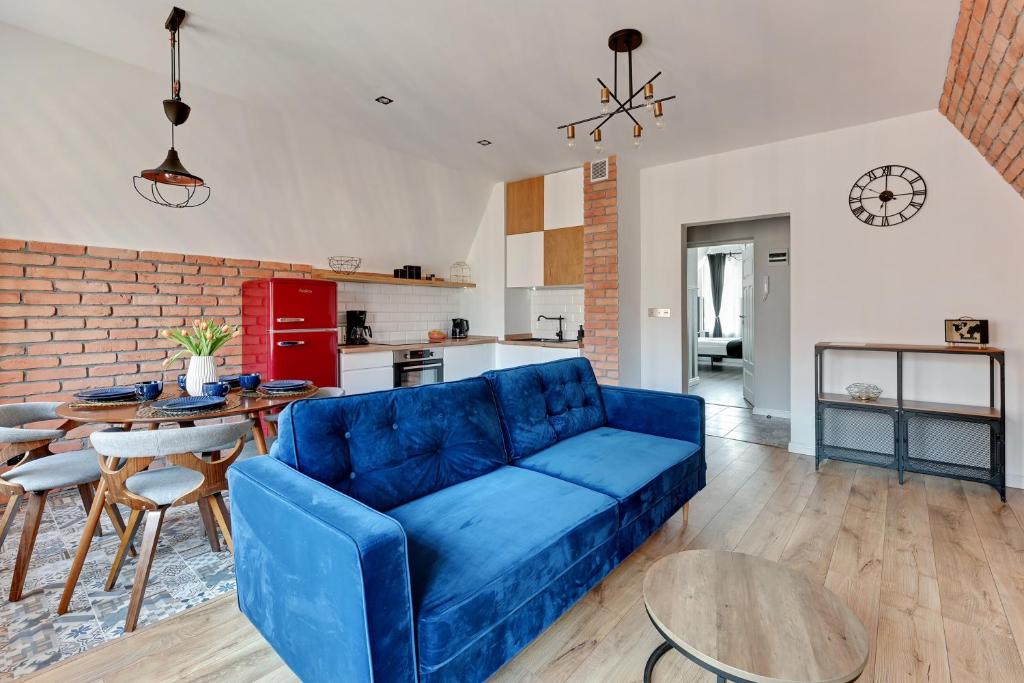 een woonkamer met een blauwe bank en een tafel bij Pola by Q4Apartments - heart of the Old Town in Gdańsk