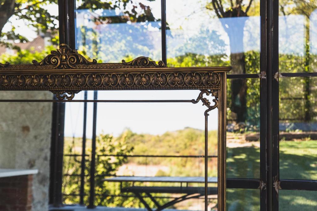 un espejo ornamentado frente a una ventana en Casa San Michele - Affittacamere Panoramico con Spa, en Parodi Ligure