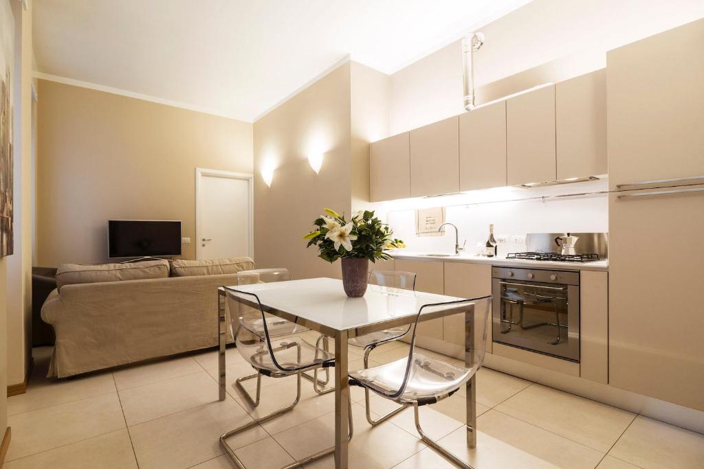 een keuken en een woonkamer met een tafel en een bank bij Contempora Apartments - Cavallotti 13 - B24 in Milaan