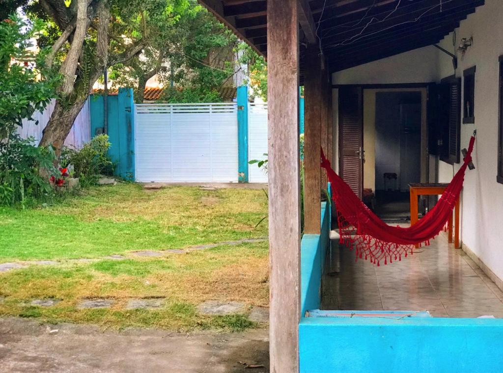 uma casa com uma rede vermelha num quintal em Hostel Blue House Búzios em Búzios