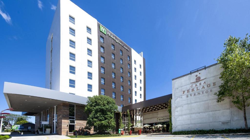 ファホウピーリャにあるHoliday Inn Express - Farroupilha, um Hotel IHGの看板が貼られた白い大きな建物