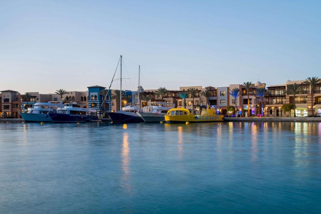 een groep boten aangemeerd in een haven met gebouwen bij Marina Resort Port Ghalib, a member of Radisson Individuals in Port Ghalib