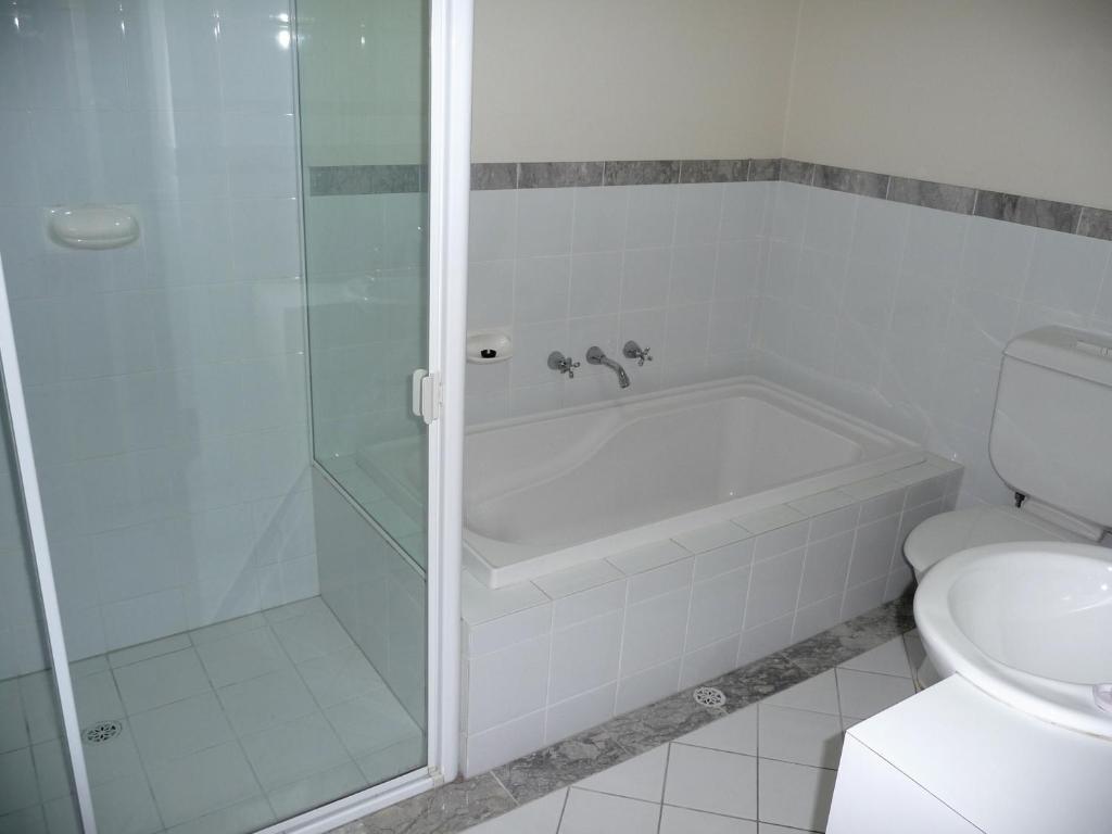 La salle de bains est pourvue d'une douche, d'une baignoire et de toilettes. dans l'établissement Superb Stay in Adelaides East End, à Adélaïde
