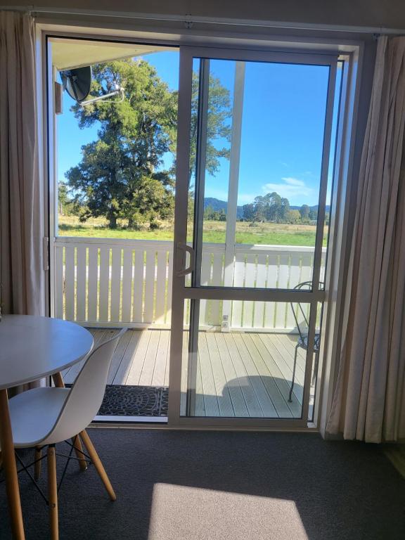 a view of a balcony with a table and chairs at Misty Peaks Cottage in Fox Glacier