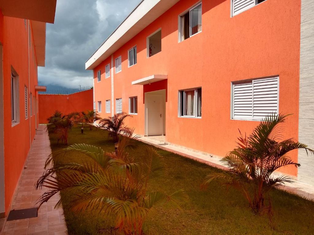 an orange building with palm trees in front of it at Casa em Villagio em Boracéia próximo a praia. in Bertioga