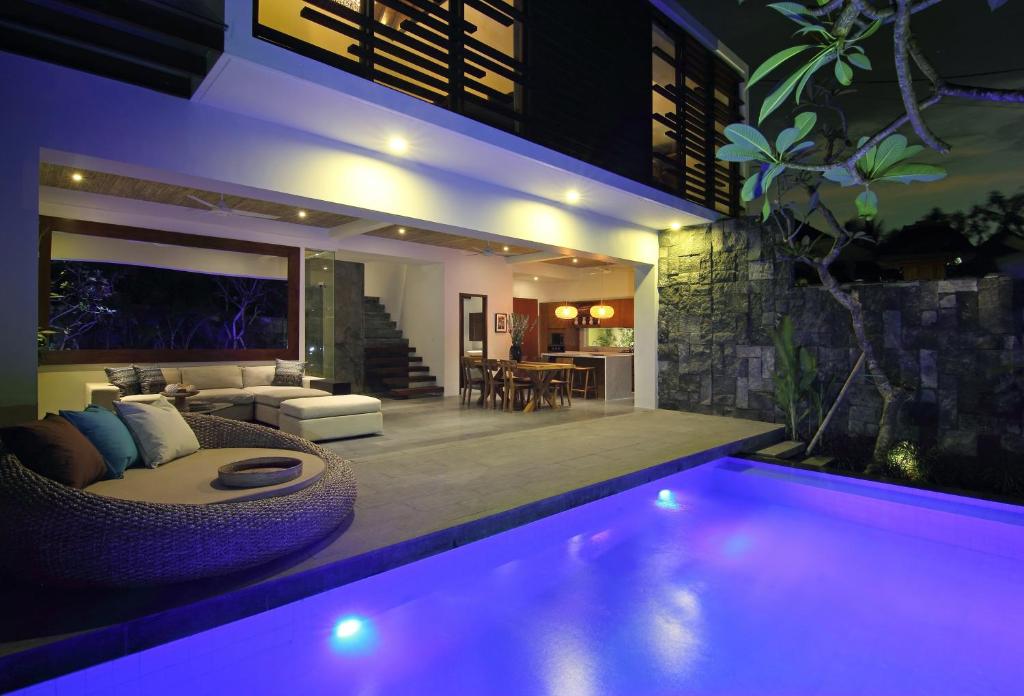 a house with a swimming pool at night at Abivilla in Seminyak
