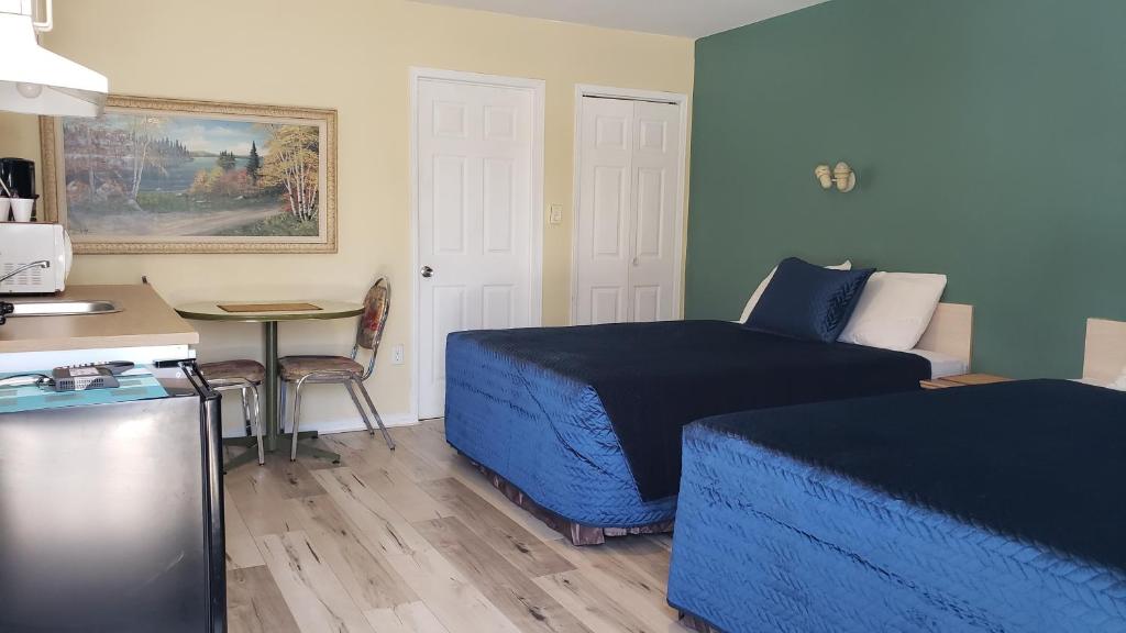 格雷文赫斯特的住宿－Oakwood Motel，一间卧室配有一张床、一张桌子和一张桌子