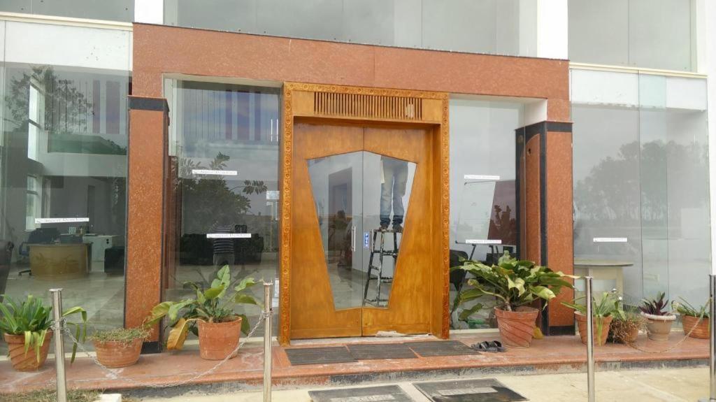 uma grande porta de madeira num edifício com vasos de plantas em Airport Residency em Bangalore