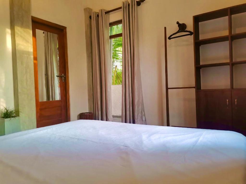 um quarto com uma cama branca e uma janela em Nilupul Villa em Ambalangoda