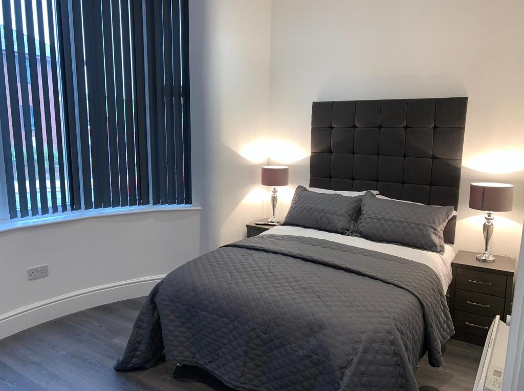 1 dormitorio con 1 cama grande y 2 lámparas en Albert Luxury Hottub & Jacuzzi Apartments, en Blackpool
