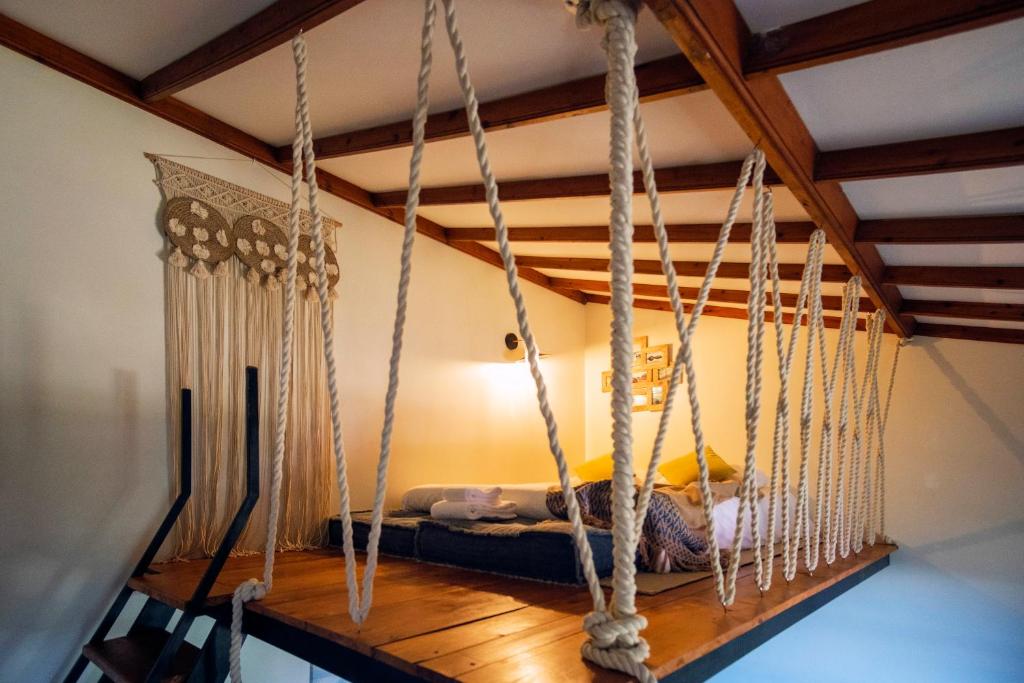 a swing in a room with a bed at O Refúgio - Espaço natural, amplo e privado in Angra do Heroísmo