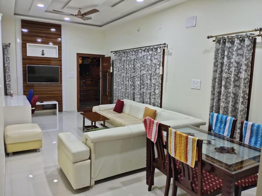 a living room with a couch and a table at Corner apartment, 2BHK with good privacy, parking in Bangalore