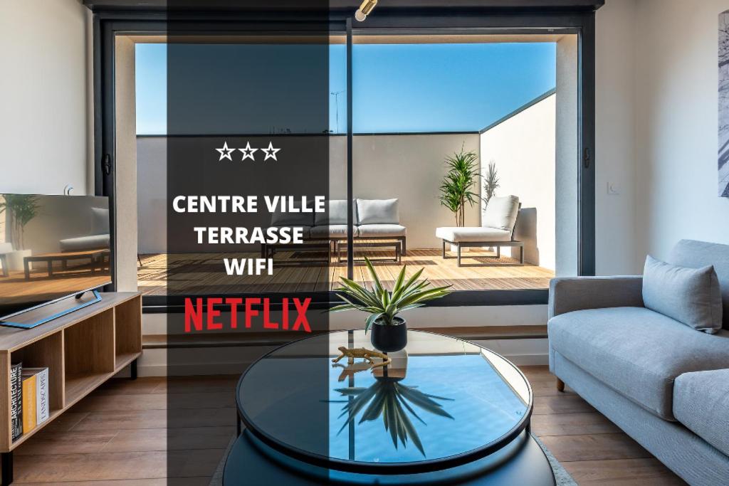 a living room with a coffee table and a tv at DOWNTOWN ROOFTOP - CENTRE VILLE - WiFi - TERRASSE - NETFLIX in Amiens