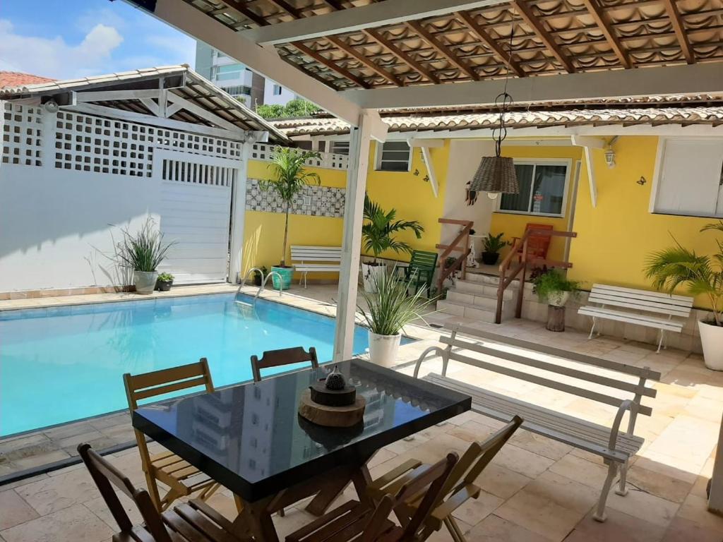 a patio with a table and chairs next to a swimming pool at atalaia mar I in Aracaju