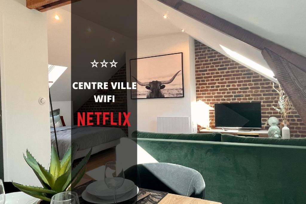 - un salon avec un canapé vert et une télévision dans l'établissement DOWNTOWN LOFT - CENTRE VILLE - WiFi - NETFLIX, à Amiens