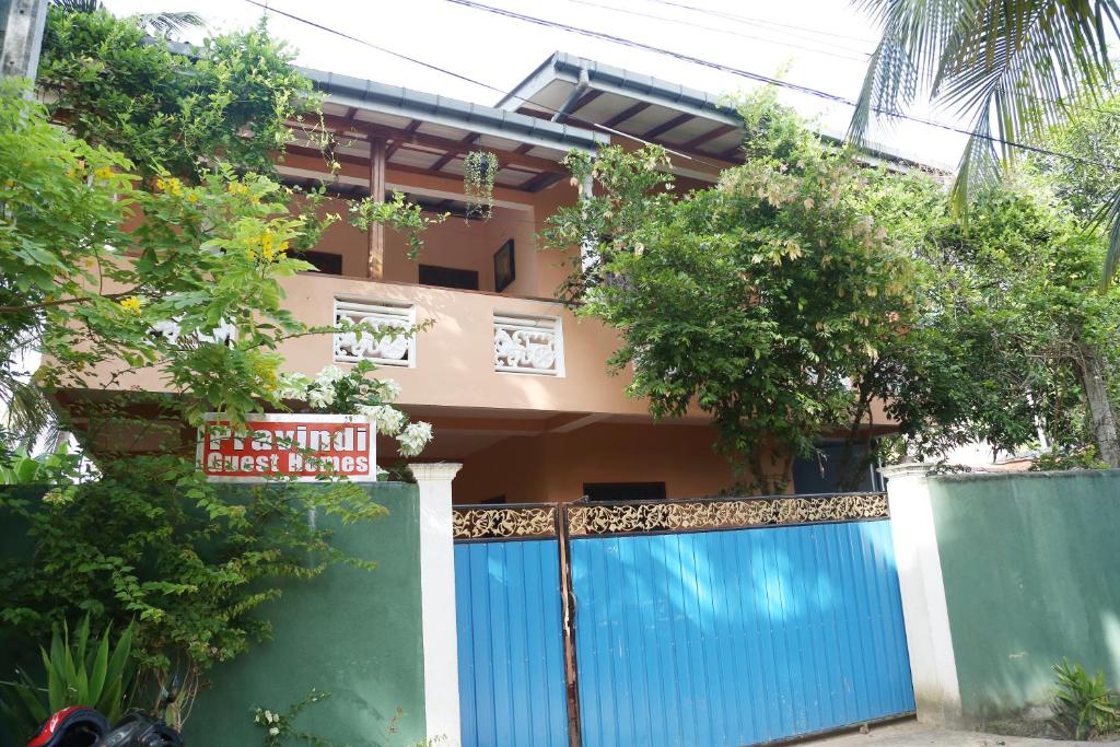 una casa con una puerta azul delante de ella en Pravindi Guest Home en Mirissa