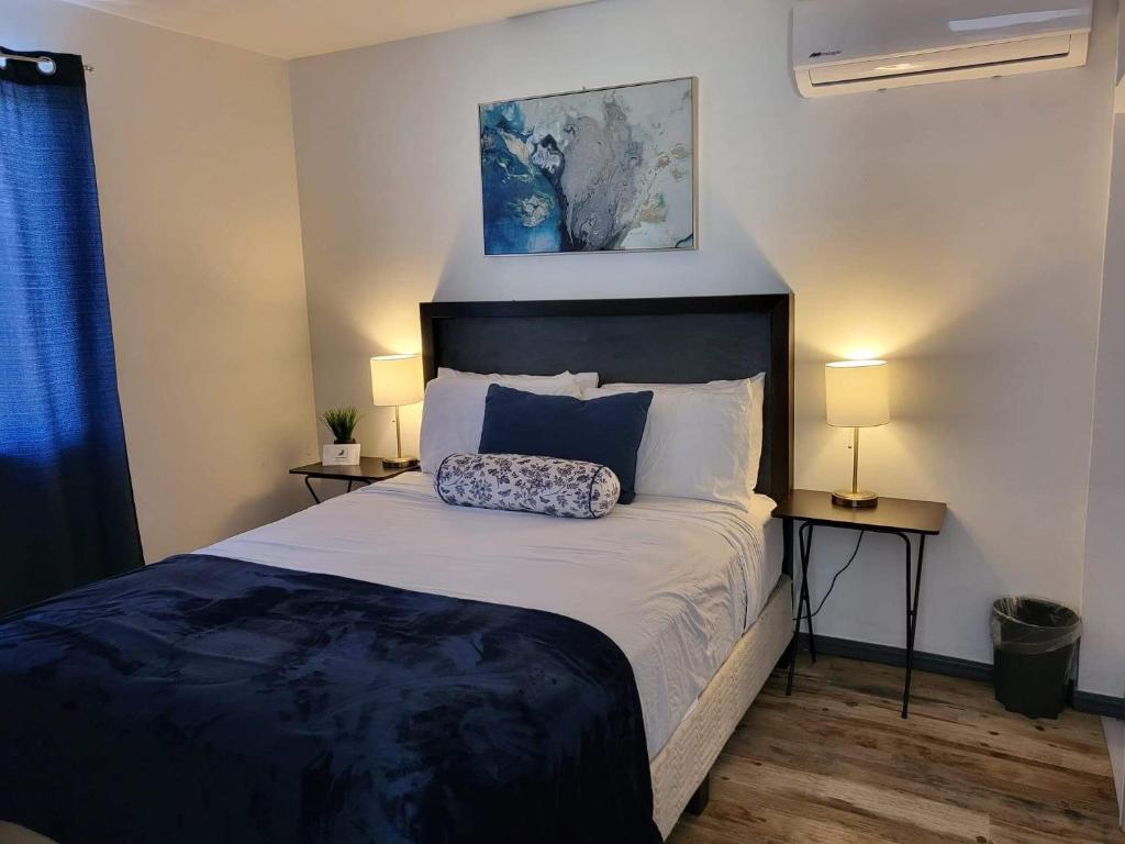 a bedroom with a bed and two tables with lamps at The White Bungalow in Rosarito