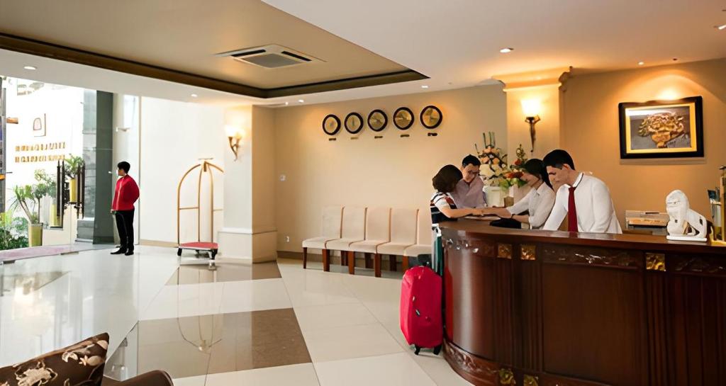 a group of people standing at a bar in a restaurant at White Lion Hotel in Ho Chi Minh City