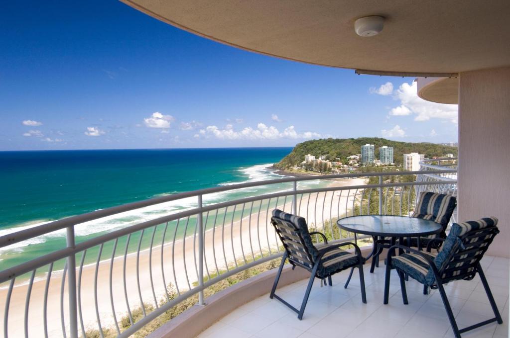 a balcony with a table and chairs and the ocean at 2nd Avenue Beachside Apartments in Gold Coast