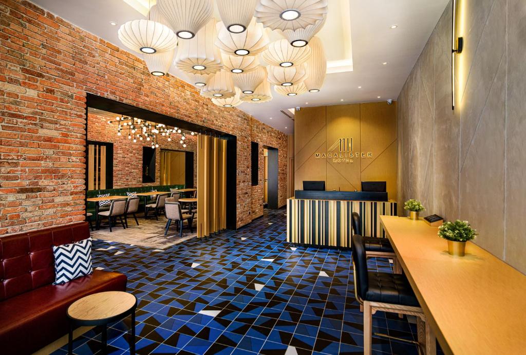 a lobby with a bar and some tables and chairs at Macalister Hotel by PHC in George Town