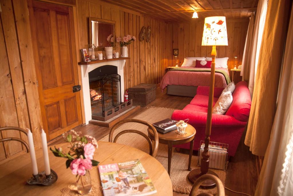 a living room with a bed and a fireplace at Red Cottages Staveley in Staveley