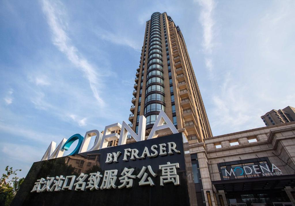 a tall building with a sign in front of it at Modena by Fraser Zhuankou Wuhan in Wuhan