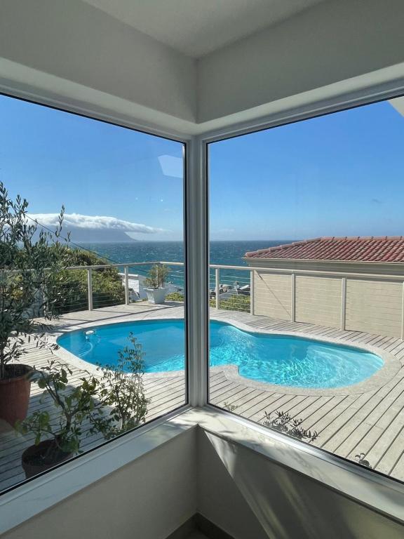 uma vista para uma piscina a partir de uma janela em Whale Rock em Cidade do Cabo