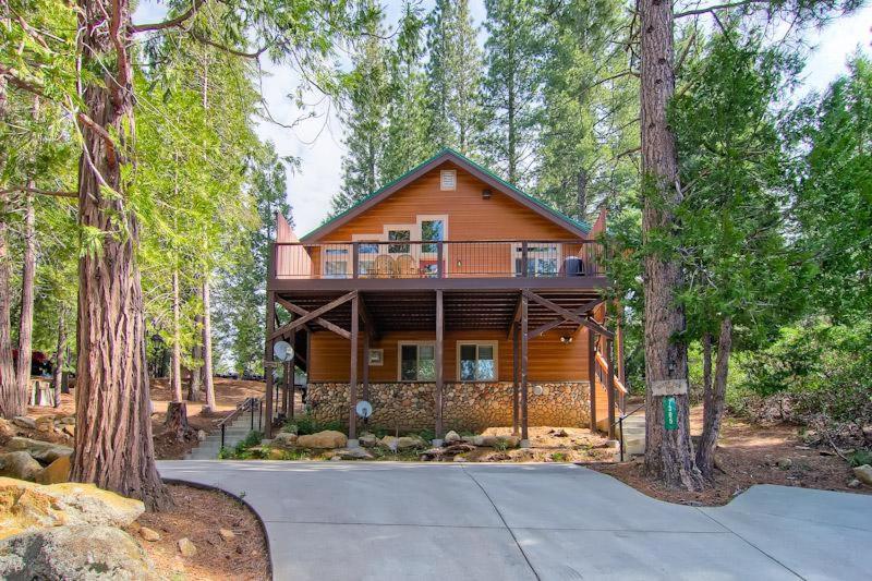 a large wooden house in the middle of the forest at Bears Den & Little Bear in Yosemite West