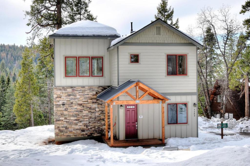 une maison avec une porte rouge dans la neige dans l'établissement Eureka, à Yosemite West