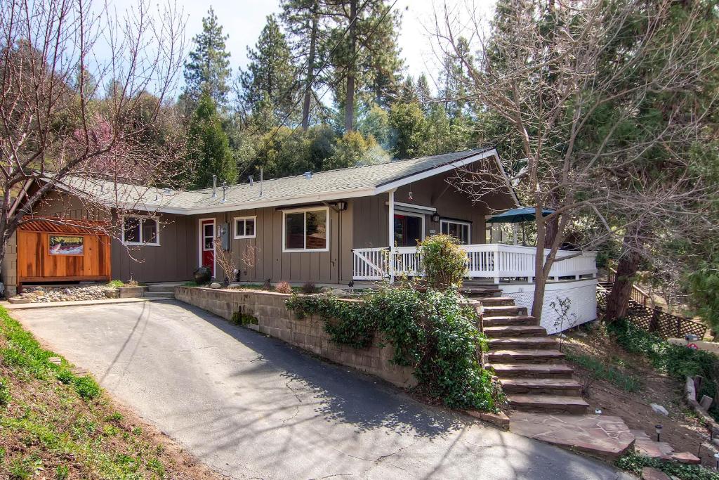 una pequeña casa con porche y entrada en Fishermen’s Oasis, en Oakhurst