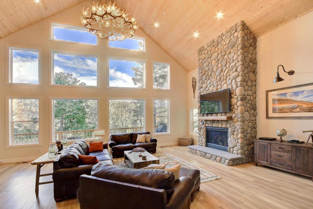a large living room with a large stone fireplace at River Rock Retreat in Yosemite West