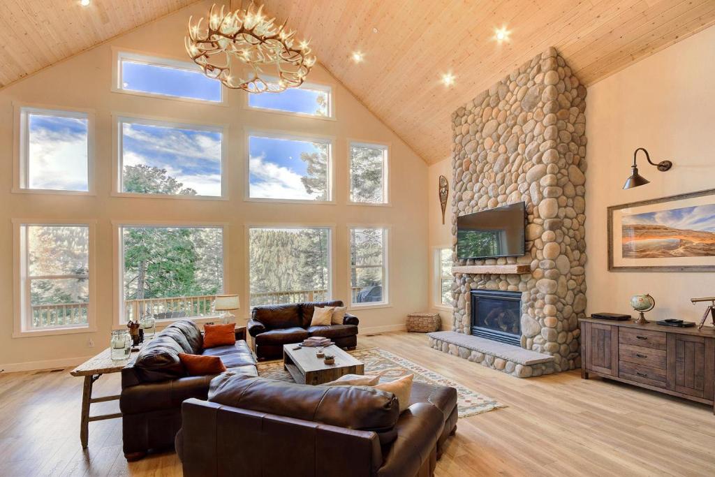 una gran sala de estar con una gran chimenea de piedra. en River Rock Retreat, en Yosemite West