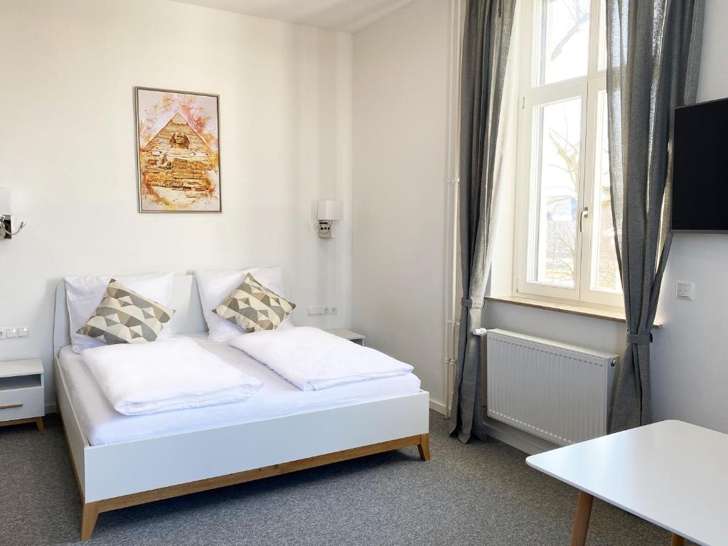 1 dormitorio con cama blanca y ventana en Best Boarding House, en Hanau am Main
