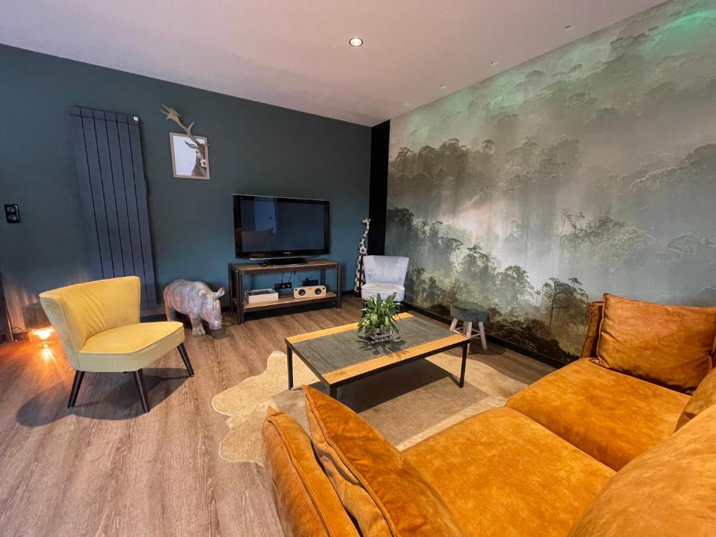 salon z kanapą i telewizorem w obiekcie Gîte Serenida w mieście Criquebeuf-sur-Seine