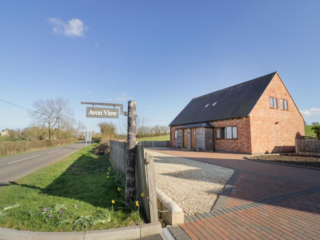 a brick building with a street sign next to a road at Rose Cottage in Stratford-upon-Avon