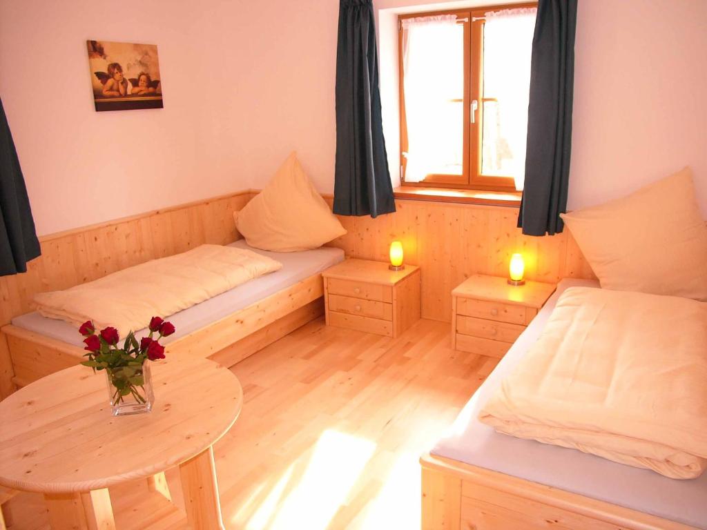 mały pokój z 2 łóżkami i stołem w obiekcie Gästehaus Weissenbauer w mieście Lenggries