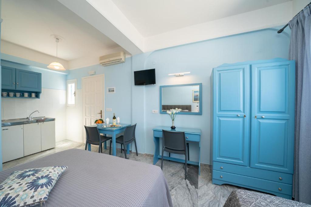 a blue bedroom with a table and a blue cabinet at Prince Studios in Sami