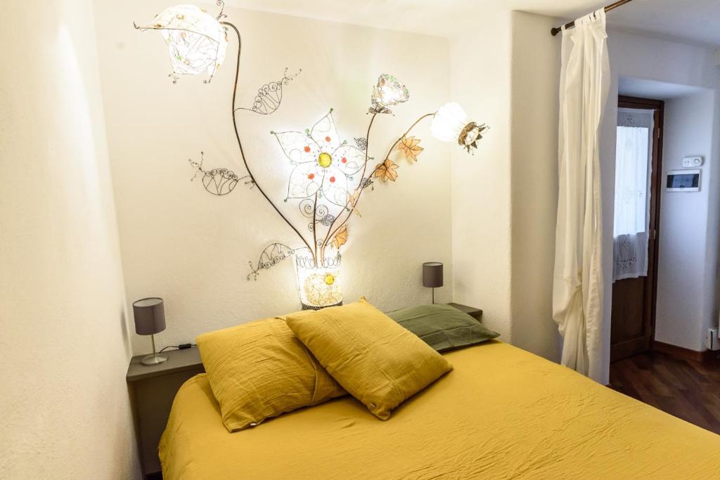 a bedroom with a yellow bed with a flower mural on the wall at DeTillierStudiò in Aosta