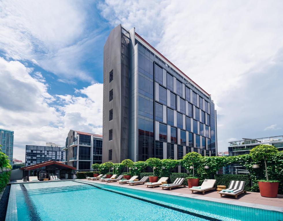 a hotel with a swimming pool and lounge chairs at M Social Singapore in Singapore