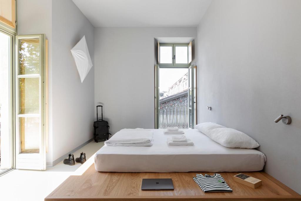 a white bedroom with a bed and a window at Combo Torino in Turin